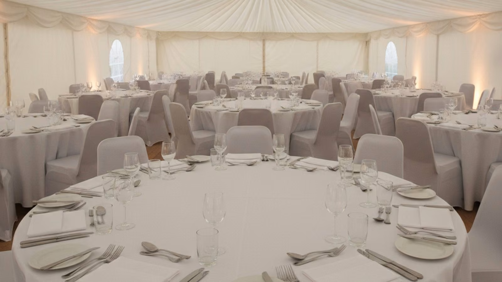 Interior of a white lined marquee set for a formal dinner