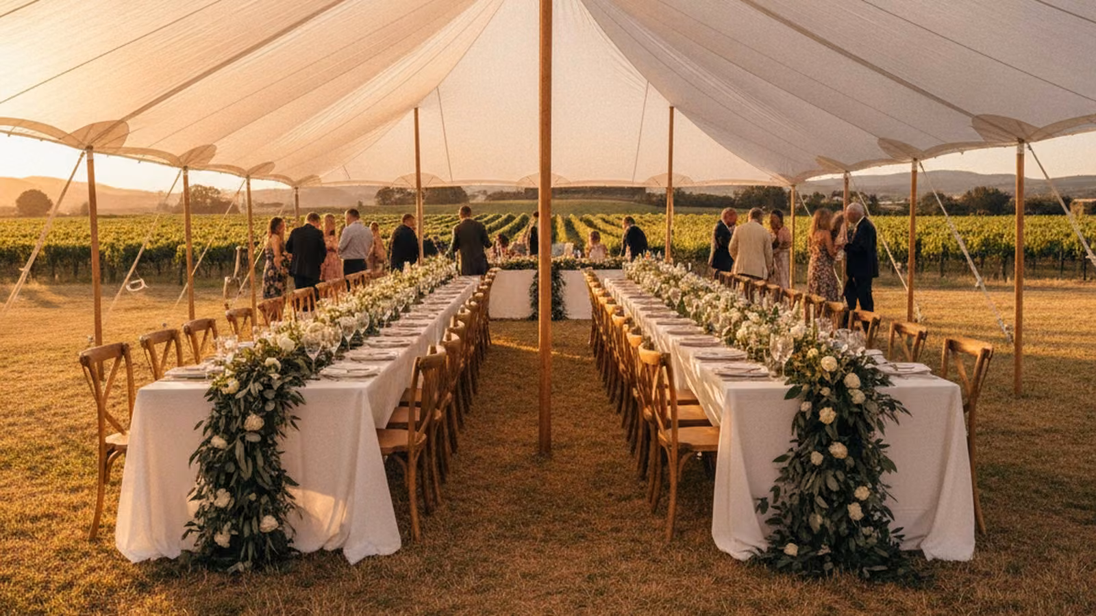 Stretch tent wedding reception on a wine estate lawn at golden hour